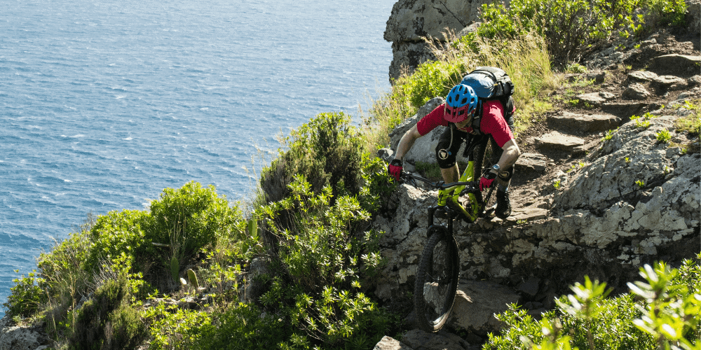 A mountain biker riding down a rocky trail.