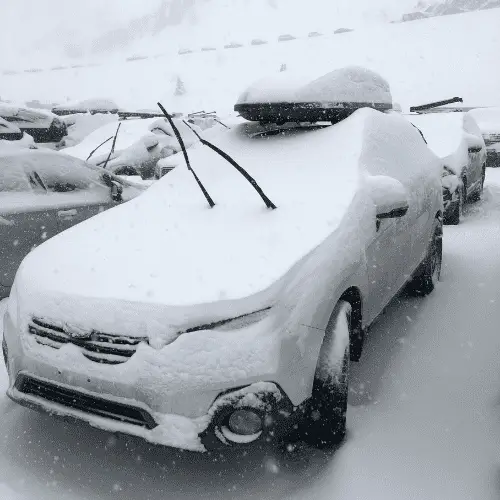 Car covered in snow on a powder day.