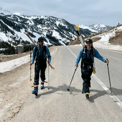 Skiers walking in ski bibs.