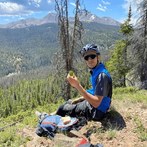 Man eating avocado mountain biking